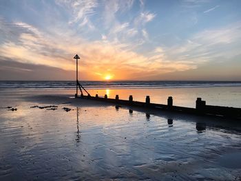 Scenic view of beach against sky during sunset