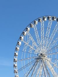 Low angle view of ferris wheel against blue sky