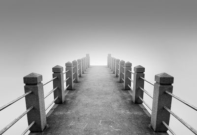 Row of railing against clear sky