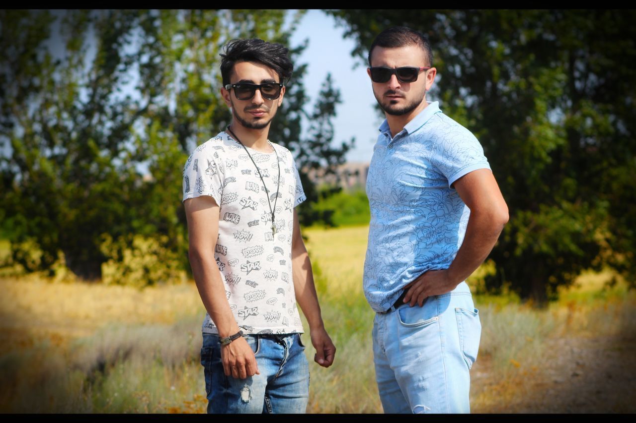 FULL LENGTH OF A YOUNG MAN STANDING OUTDOORS