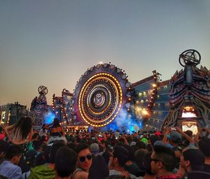 Crowd on illuminated ferris wheel at night