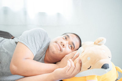 Portrait of man lying down on bed at home