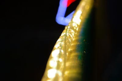 Close-up of illuminated lighting equipment against black background