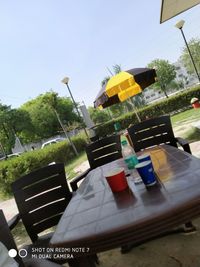Tilt image of chairs and table against sky