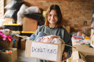 Volunteer teengirl preparing donation boxes for people.