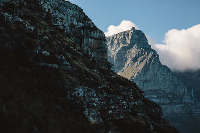 Low angle view of rocky mountains against sky