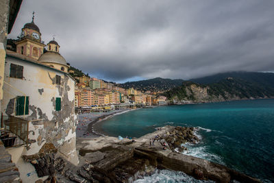 Scenic view of sea by buildings against sky