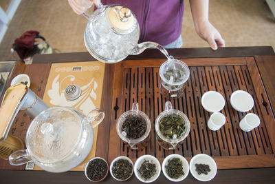 High angle view of hand making tea on table