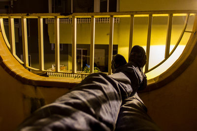 Low section of man sitting on metal railing