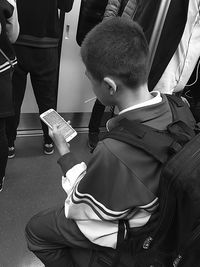 Boy using smart phone in train