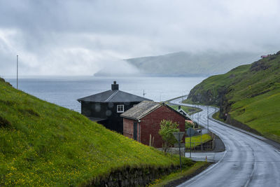 Scenic view of road by mountains against sky