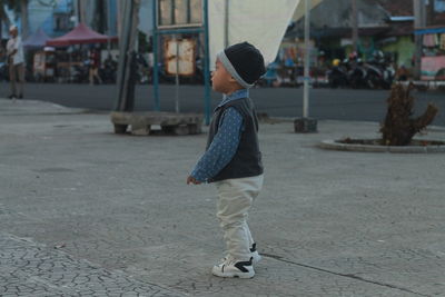 Full length of cute baby boy walking on street in city