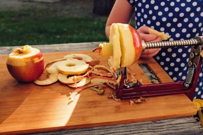 Close-up of hand holding ice cream on cutting board