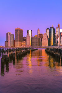 Reflection of buildings in river against sky