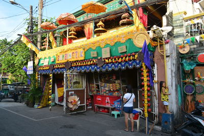 People at amusement park by buildings