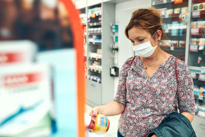 Mature woman wearing flu mask in store