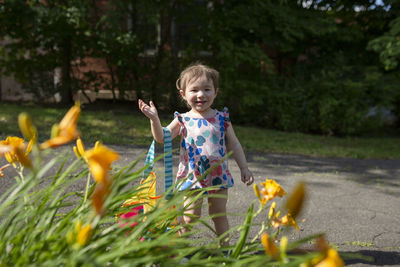 Portrait of smiling girl holding flowering plant