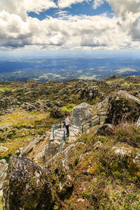 High angle view of man standing on rock against sky