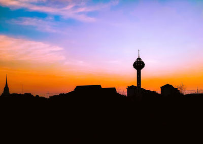 Silhouette buildings against sky during sunset