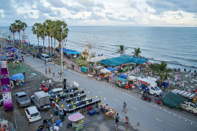 High angle view of people on street by sea against sky