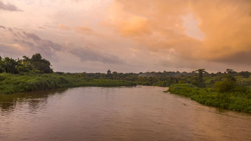 Scenic view of river against sky at sunset