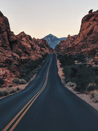 Road amidst mountains against clear sky