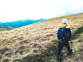 Portrait of young woman with umbrella walking on mountain