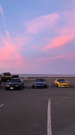 Cars on road against sky during sunset