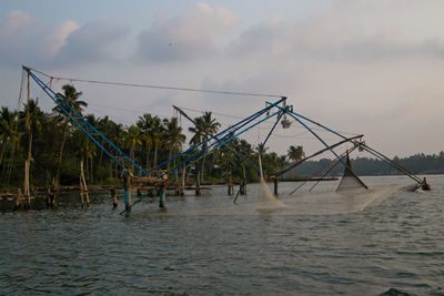 Fishing net in sea against sky