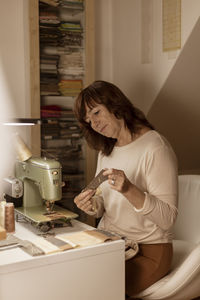 Caucasian brunette woman sewing fabric with a vintage, retro sewing machine. fashion, creation