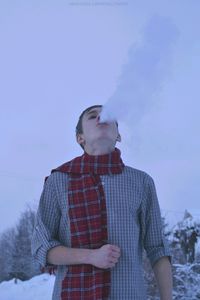 Low angle view of young man standing against sky