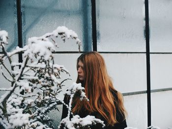 Young woman looking through window