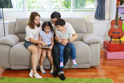Rear view of women sitting on sofa