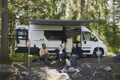 Friends relaxing in front of camper van