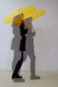 Full length of woman with umbrella standing in rain