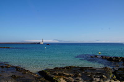 Scenic view of sea against clear blue sky