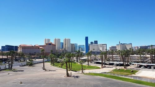 City street and buildings against clear blue sky