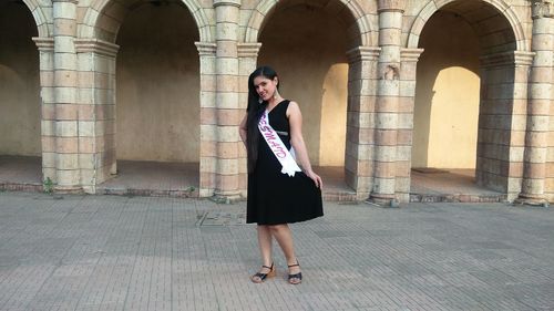 Full length portrait of young woman wearing bridesmaid sash at vardhman fantasy amusement park