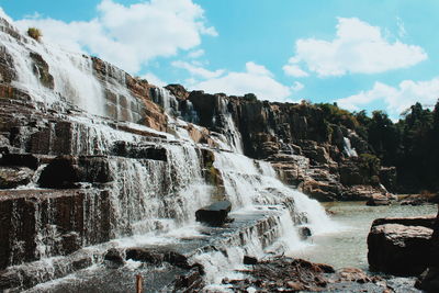 Low angle view of waterfall against sky