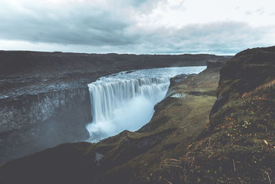 Scenic view of waterfall against sky