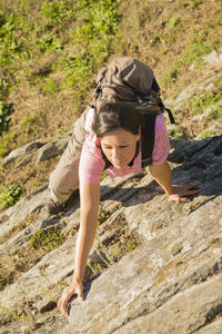 High angle view of woman climbing rock