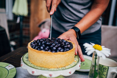 Midsection of person preparing cake on table