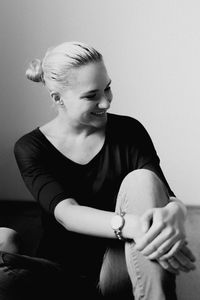 Smiling young woman sitting at home
