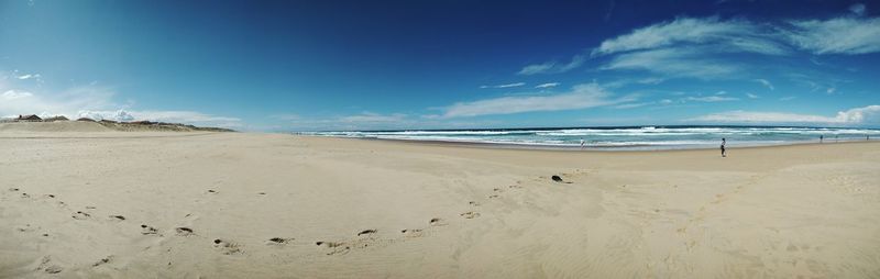 Scenic view of beach against blue sky