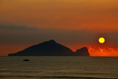 Scenic view of sea against orange sky