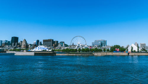 View of city by buildings against blue sky