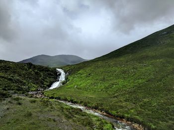 Scenic view of waterfall against sky