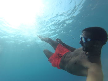 Side view of young man swimming in sea