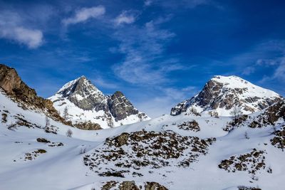 Scenic view of snowcapped mountains against blue sky