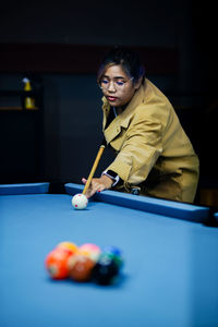 Portrait of woman playing pool